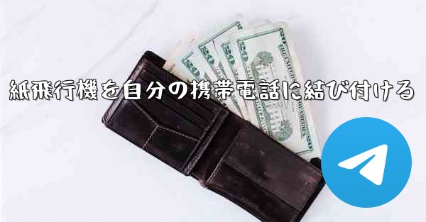 紙飛行機を自分の携帯電話に結び付ける